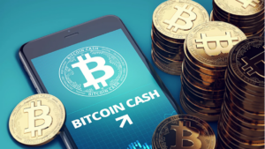 golden bitcoin coins and smartphone with bitcoin cash logo